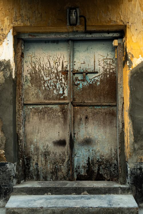 Free A vintage, weathered metal door with a padlock on rough textured, painted background. Stock Photo