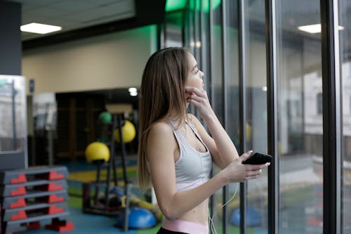 Woman Inside A Gym Holding Smartphone