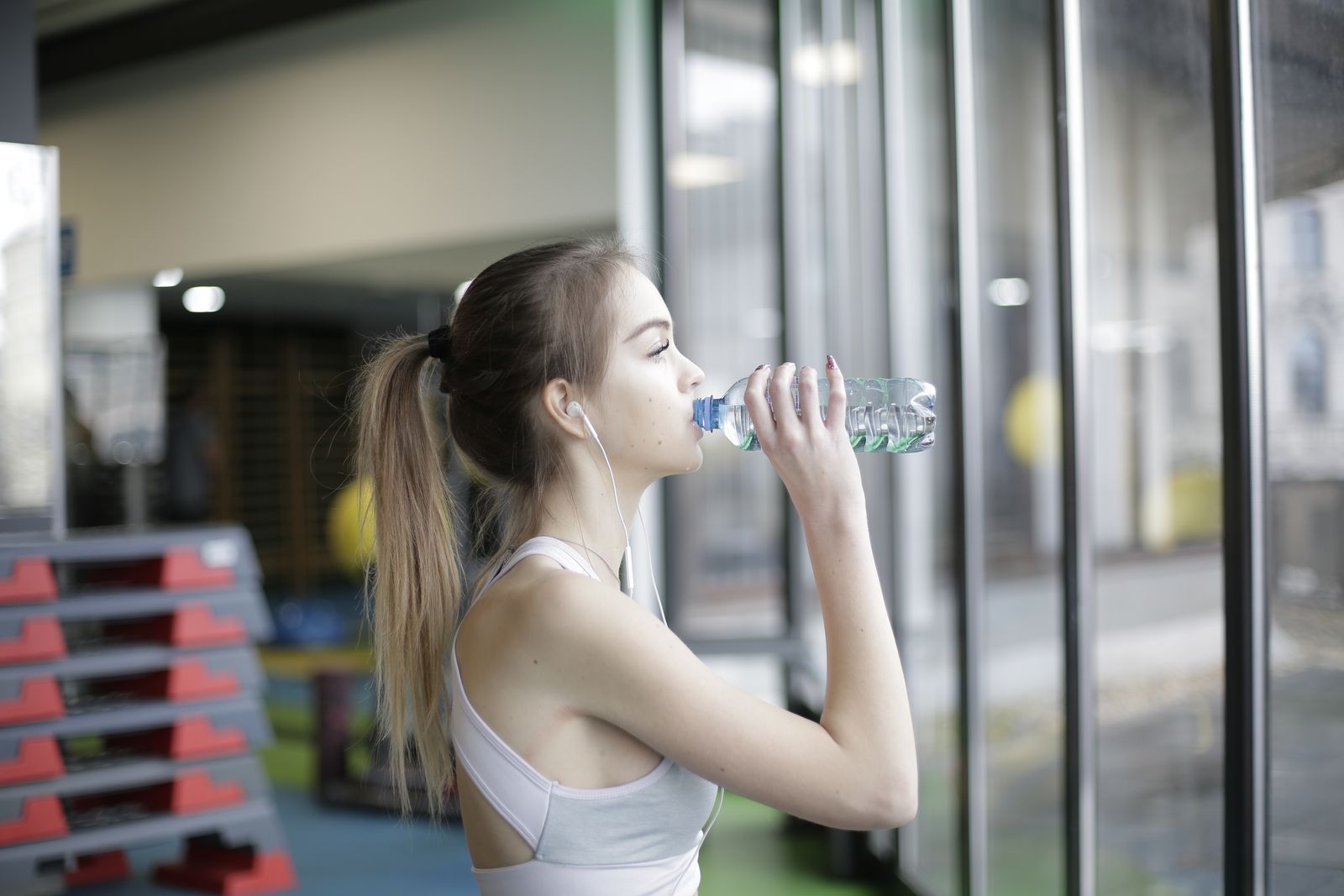 Woman drinking water from a bottle during a workout break