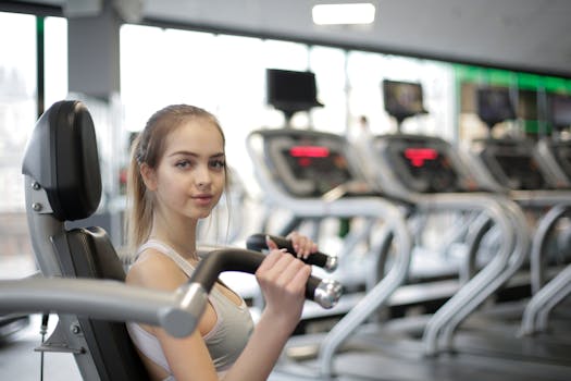 A young woman working out in a modern gym setting with exercise machines.