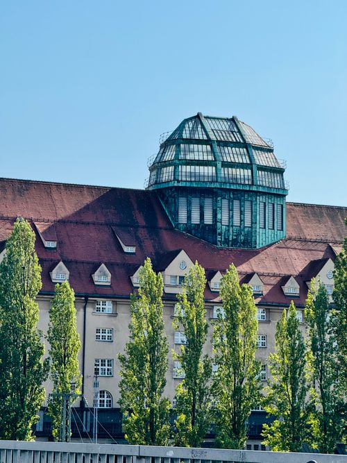 Free Stunning view of a historic Munich building featuring a prominent glass dome and surrounded by trees. Stock Photo