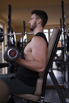 Fit man exercising with a dumbbell at the gym, focused on building upper body strength.