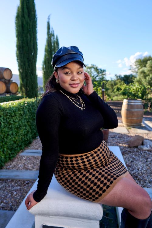 Free Young woman in fashionable outfit sitting outdoors in a vineyard. Stock Photo