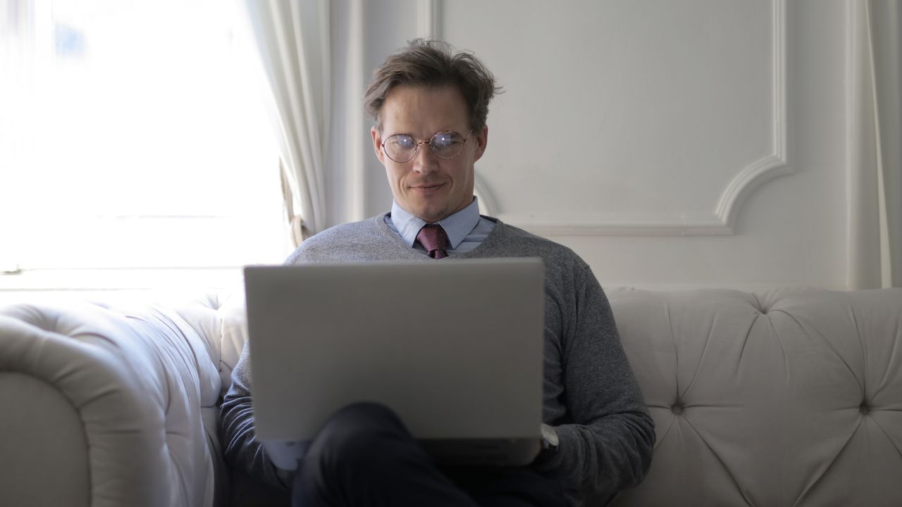 Business professional working on a laptop in a stylish, comfortable indoor setting.