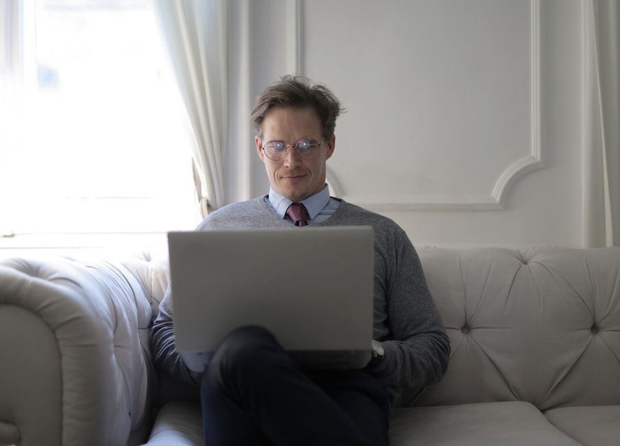 Business professional working on a laptop in a stylish, comfortable indoor setting.