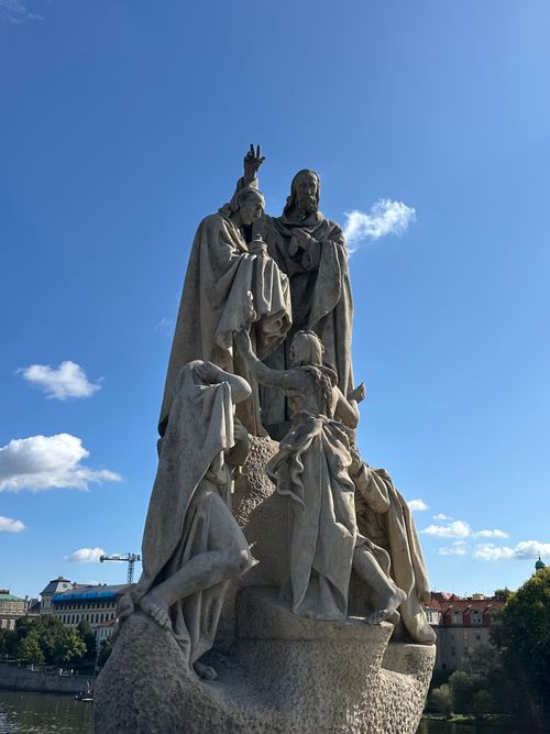 Free Marble statue on Charles Bridge in Prague against a blue sky. Stock Photo