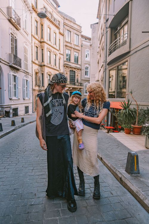 Free A family enjoys a leisurely walk on a picturesque cobblestone street in Europe. Stock Photo