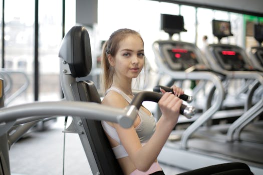 Adult woman engaging in a workout session inside a gym using fitness equipment.