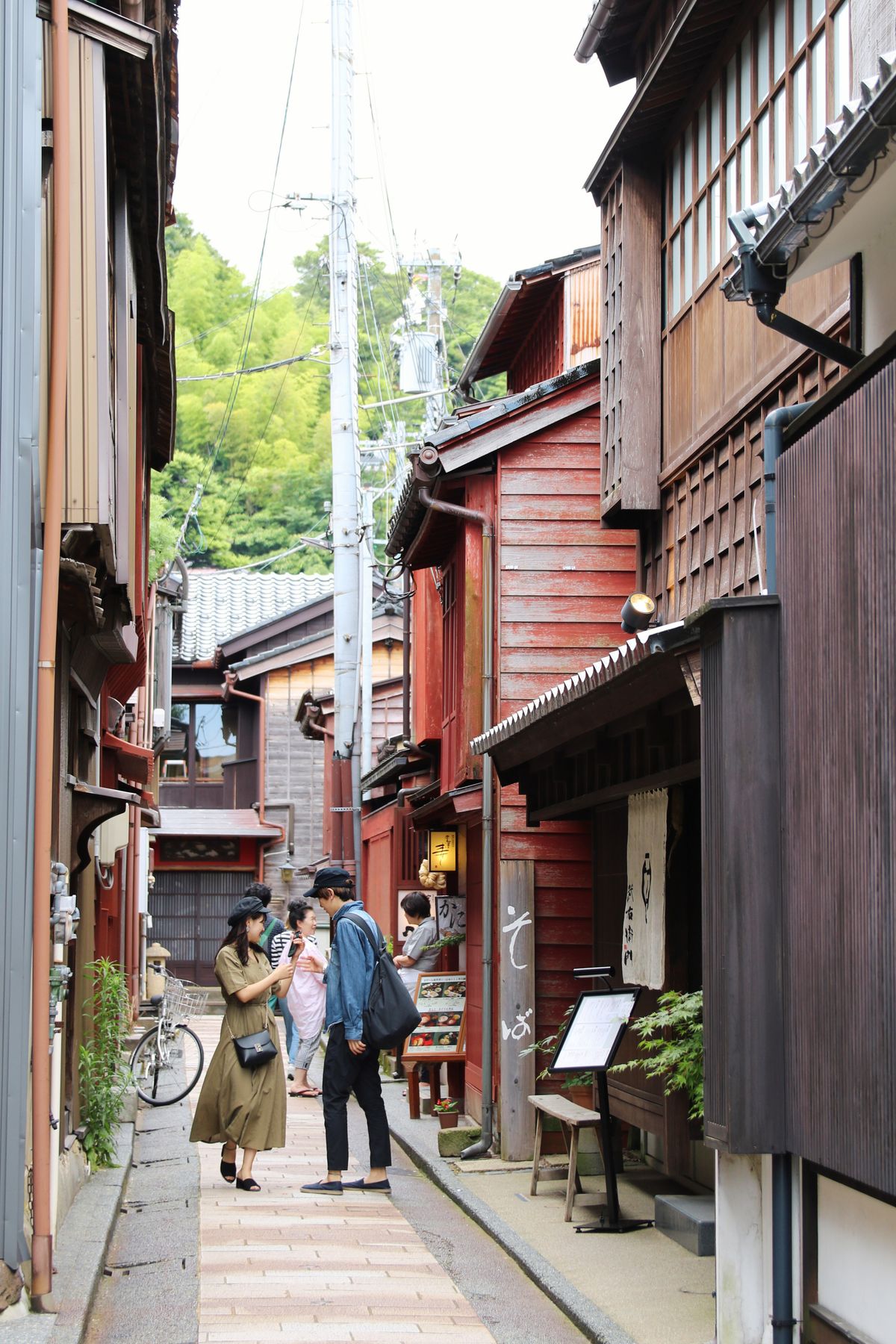 Narrow lane of dark wooden teahouses with latticed fronts in the Higashi Chaya District of Kanazawa