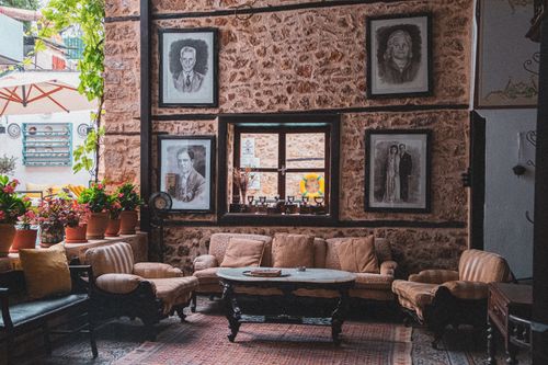 Free A cozy vintage living room with portraits, wooden furniture, and potted plants, exuding warmth and charm. Stock Photo