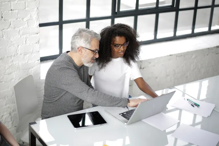 Two professionals planning a customer campaign at a laptop