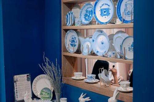 Free Charming display of vintage blue and white plates on a wooden shelf, set against a rich blue wall. Stock Photo
