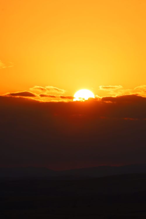 Free Bright orange sunset with clouds at the horizon, casting a warm glow. Stock Photo