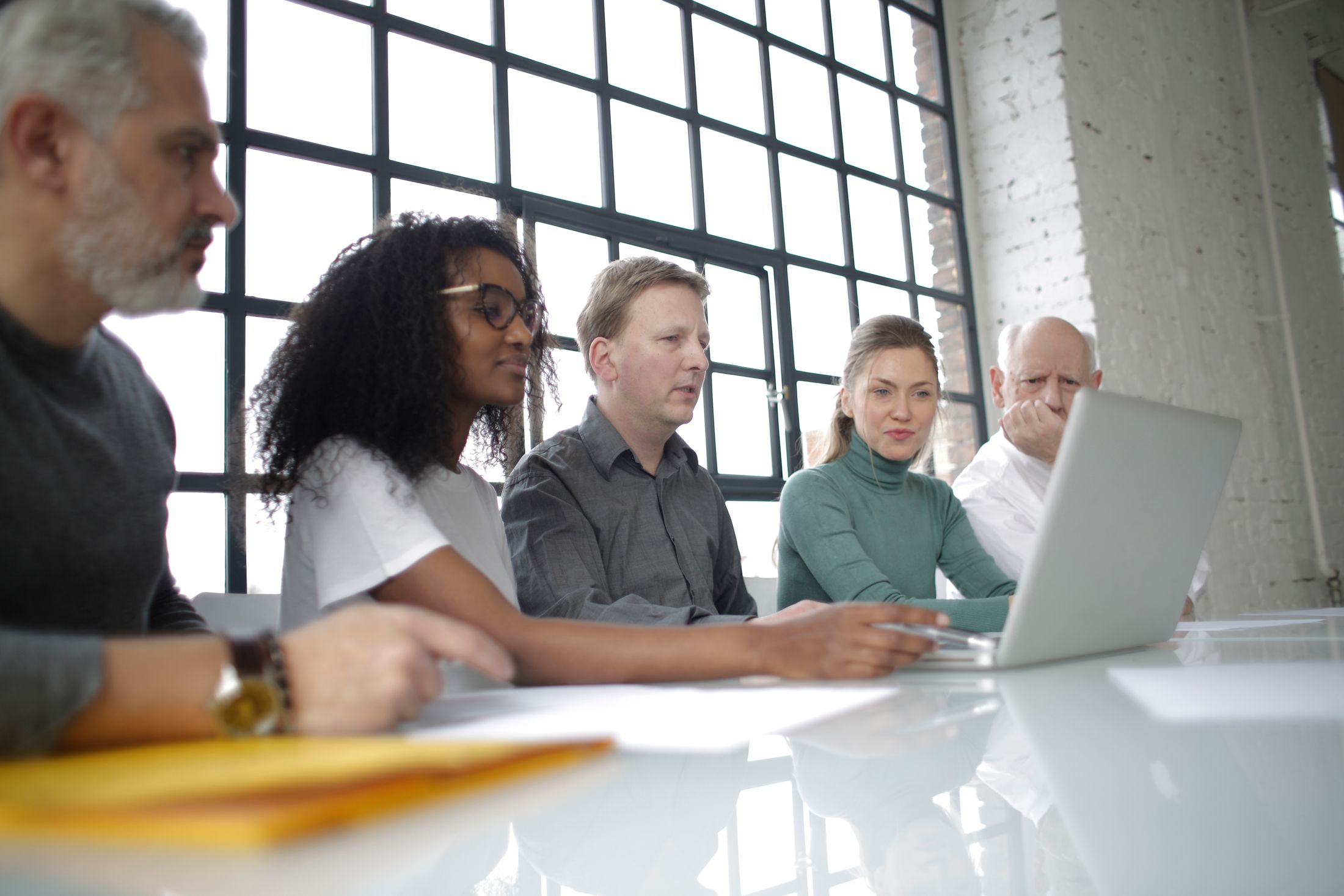 Professional team learning together around a laptop