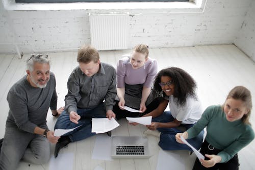 A Team Sitting On The Floor While Working