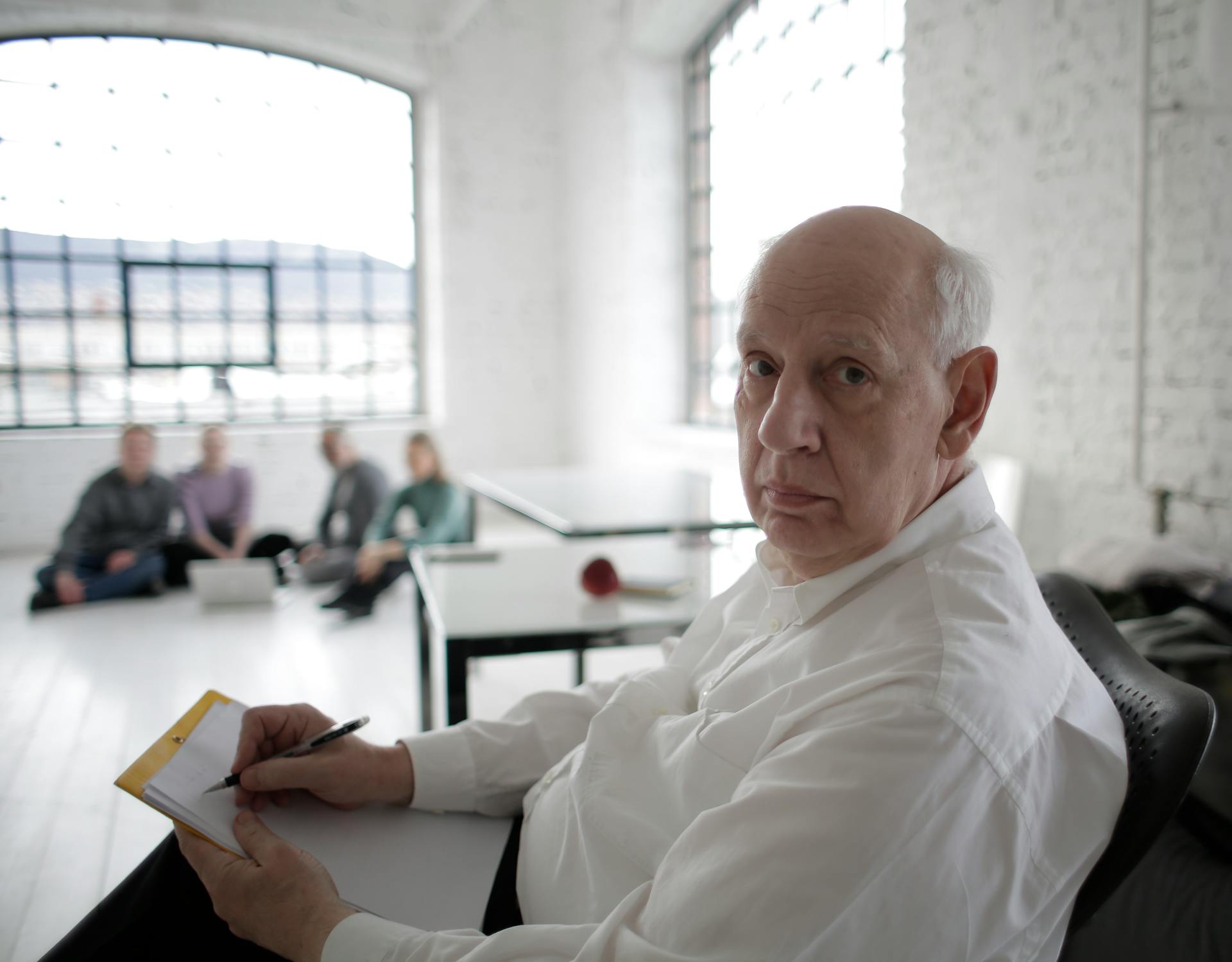 Senior male executive concentrating during a team meeting in a modern office setting.