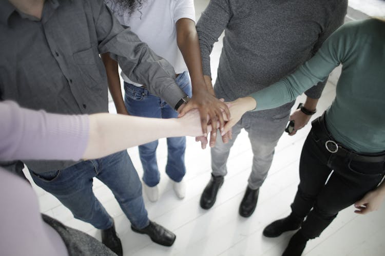 Crop Multiracial People Joining Hands Together During Break In Modern Workplace