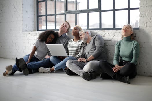 A diverse group of coworkers relaxing with closed eyes, leaning against a brick wall indoors.