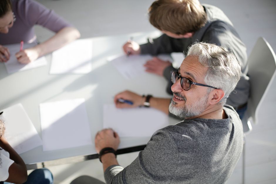 Un grupo de adultos diversos participando en una reunión colaborativa, generando ideas y compartiendo opiniones.