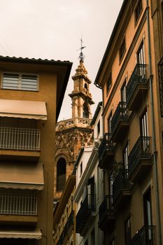 View of historic building amidst modern structures in Alicante, capturing architectural contrast.