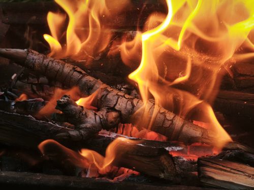Free A close-up image of a crackling fire with logs burning intensely, creating a warm and vivid atmosphere. Stock Photo