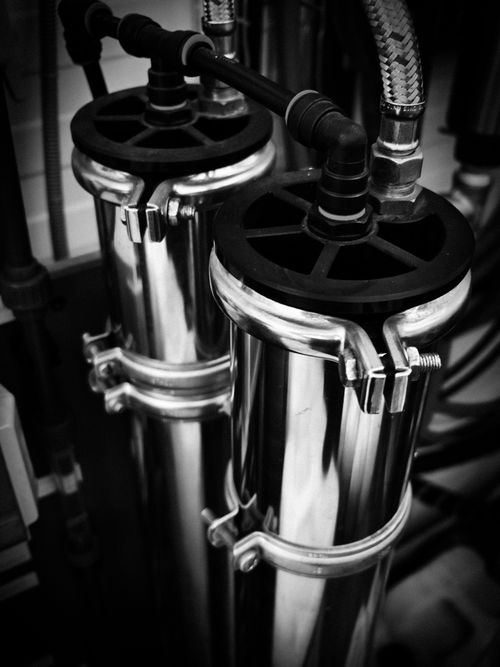 Free Close-up of metal pipes and fittings in an industrial setting. Monochrome image highlighting contrast. Stock Photo