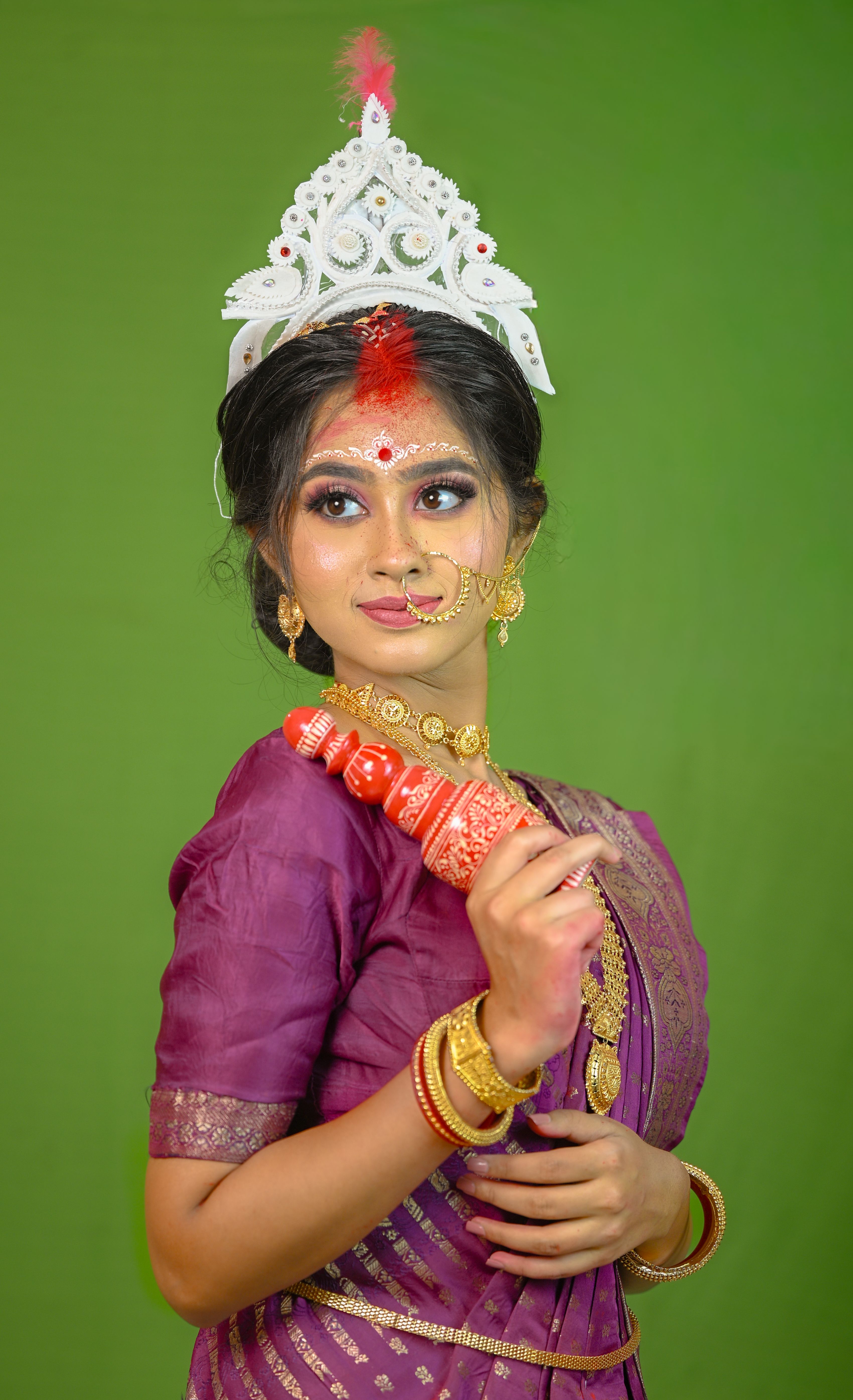 Portrait of a woman in traditional Bengali attire with ornate jewelry and headpiece.