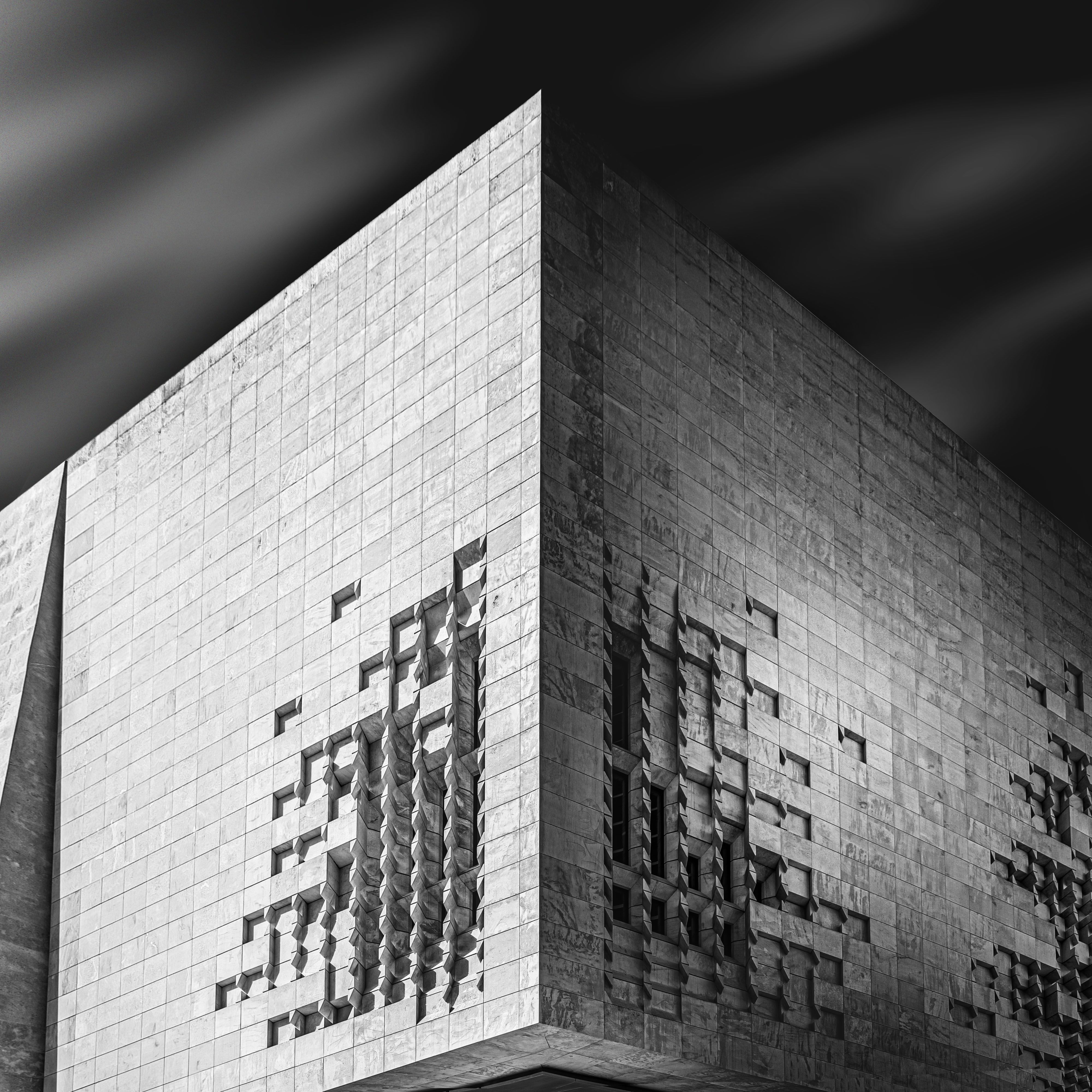 Striking black and white photo of a modern architectural building with unique geometric patterns.