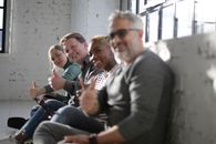Cheerful diverse friends demonstrating thumb up gesture