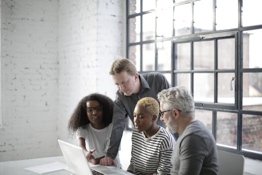 A diverse team of adults engaging in a collaborative discussion in an office setting.
