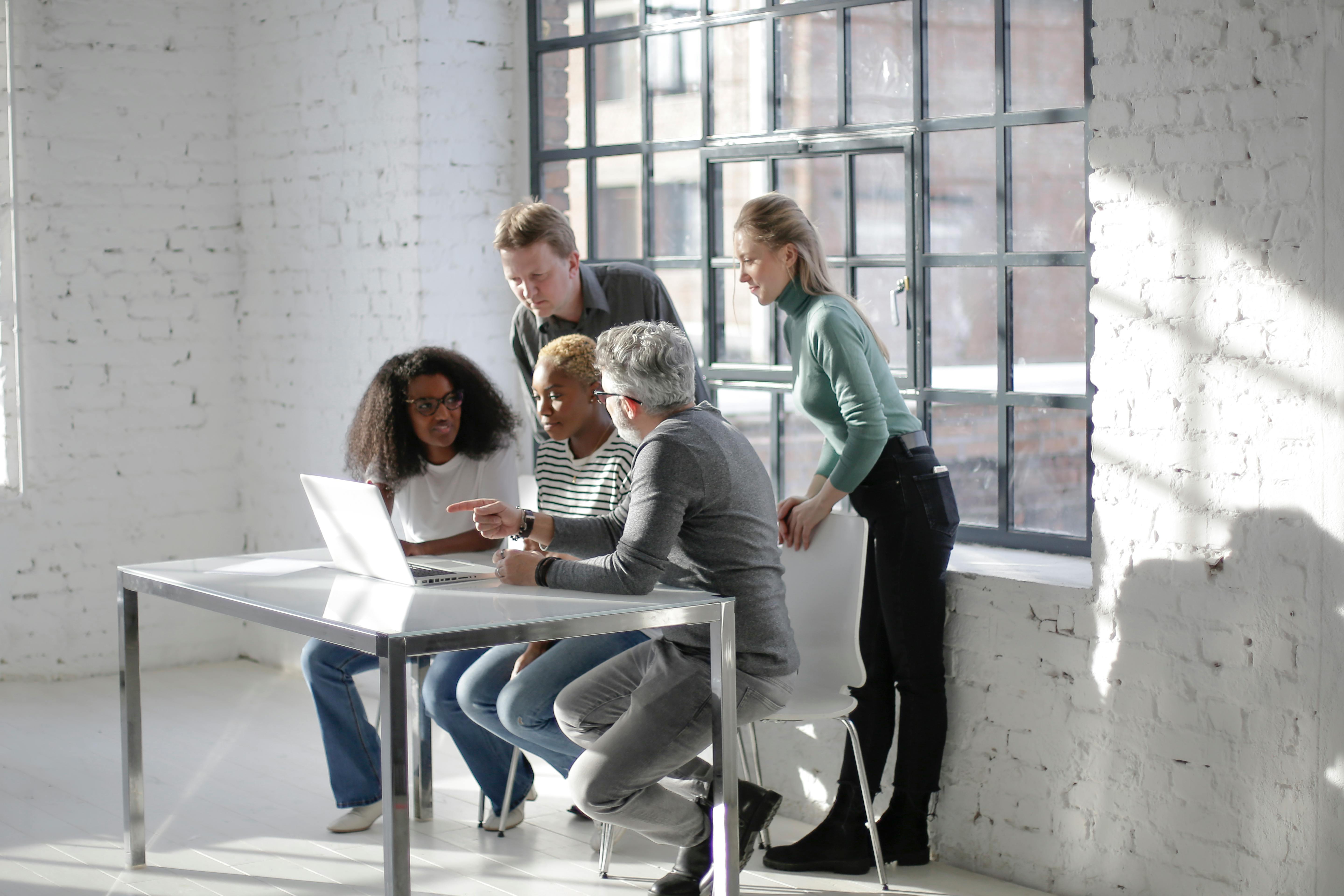 Diverse coworkers discussing project in workspace · Free Stock Photo