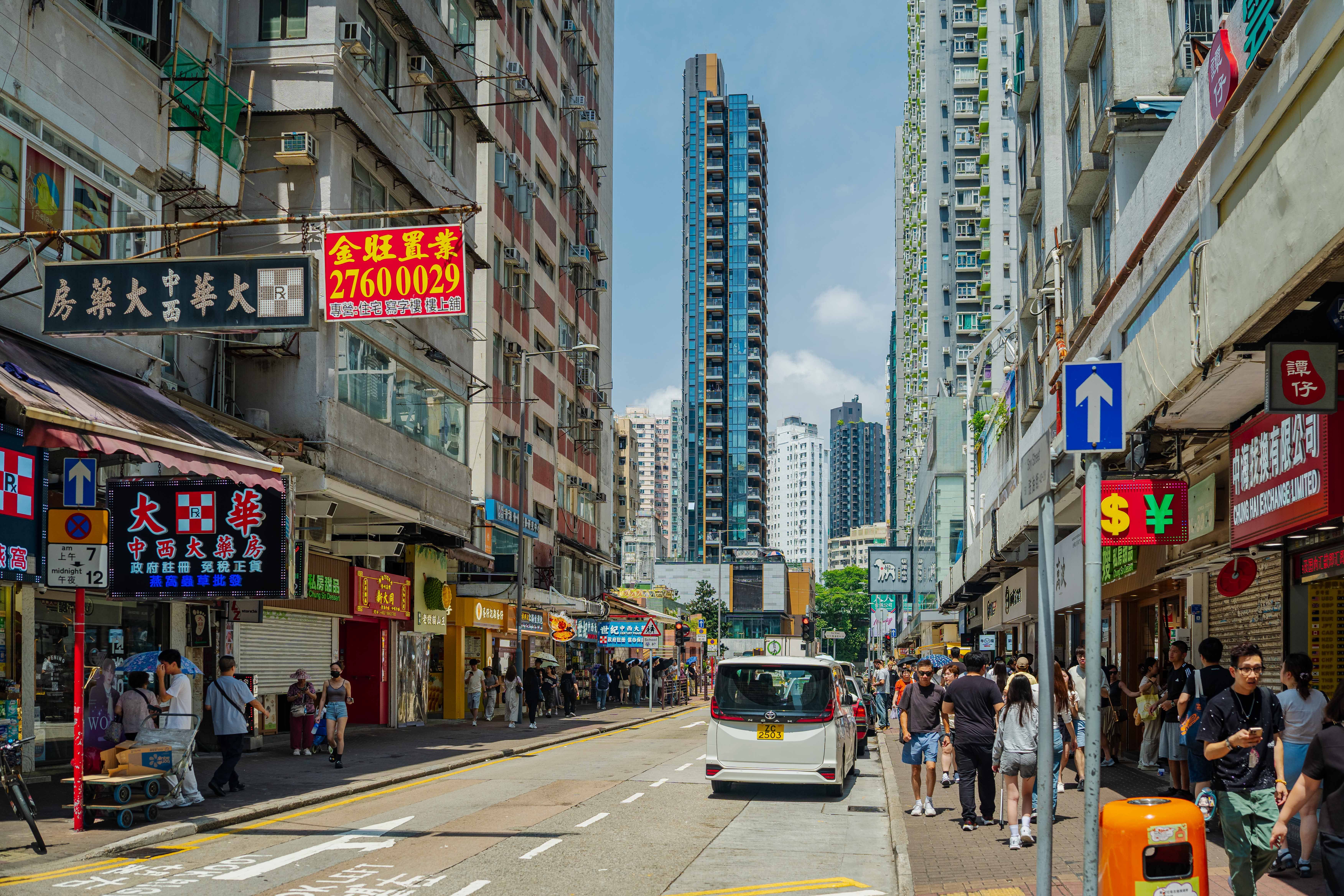 Lively daytime street view in Kowloon, Hong Kong, showcasing urban life and architecture.