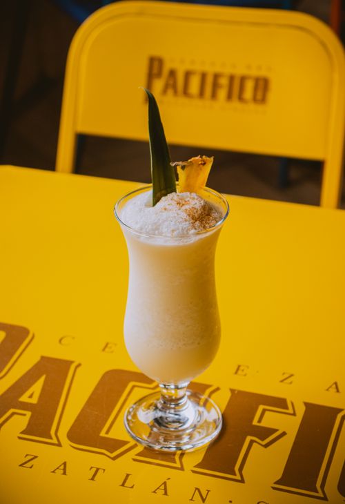Free A delicious pina colada cocktail garnished with pineapple on a yellow table. Stock Photo
