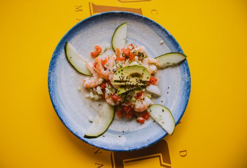Free Tasty shrimp salad with avocado and cucumber on a ceramic plate, vibrant colors. Stock Photo