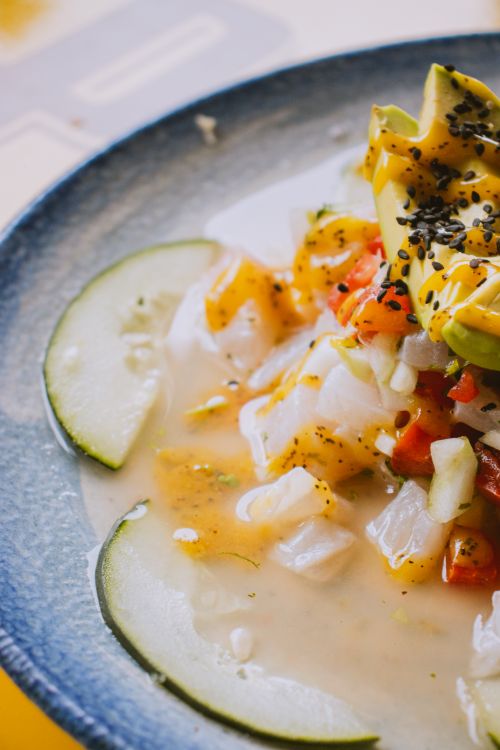 Free Close-up of vibrant ceviche with avocado and lime slices in a blue bowl, featuring fresh ingredients. Stock Photo