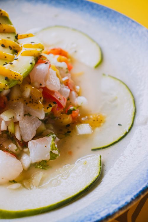 Free Close-up of a vibrant seafood ceviche dish with avocado and slices of lime, perfect for summer. Stock Photo