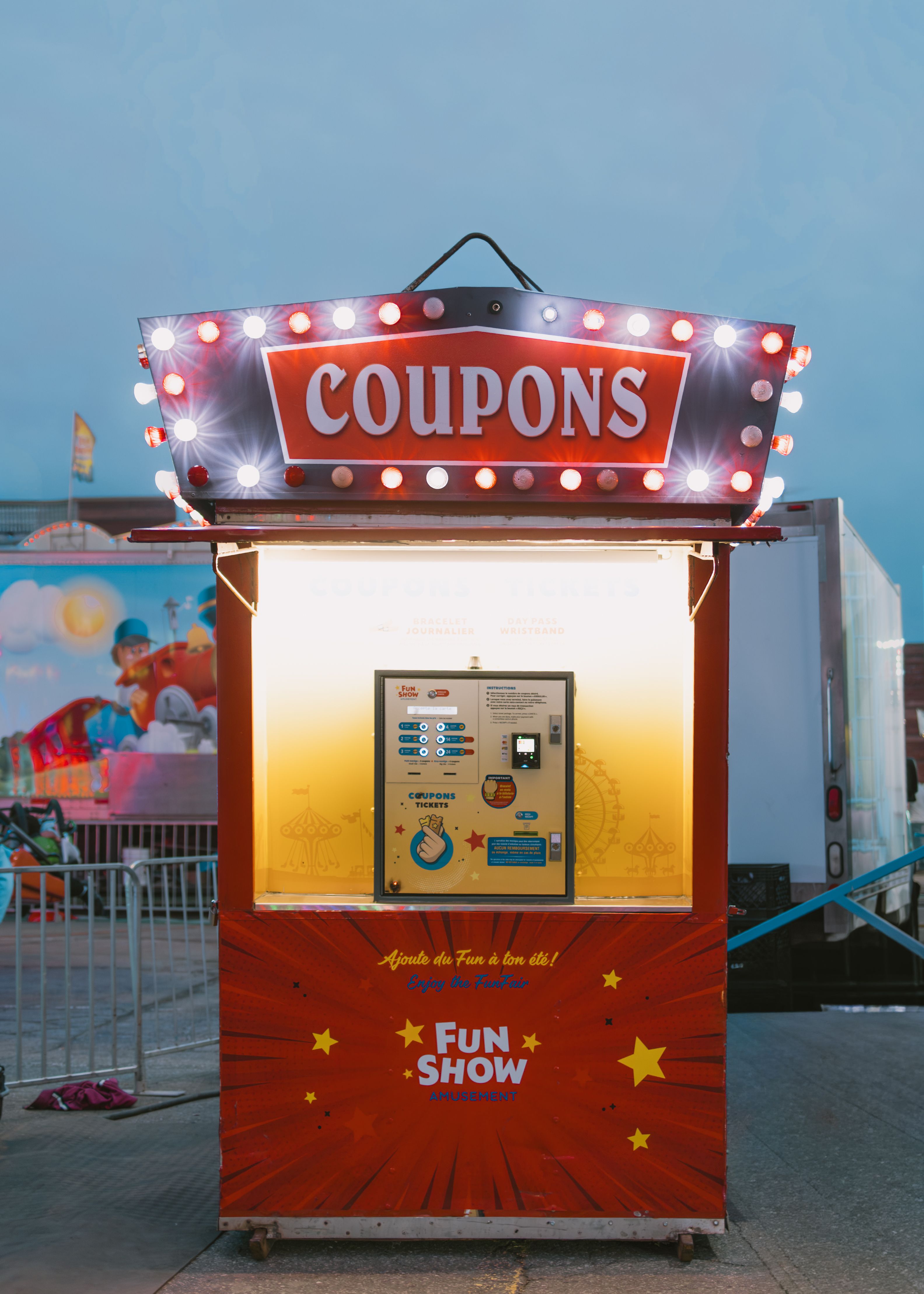 A bright coupon booth at an outdoor fairground, featuring a vibrant display and festive decorations.