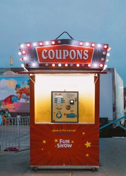 A bright coupon booth at an outdoor fairground, featuring a vibrant display and festive decorations.