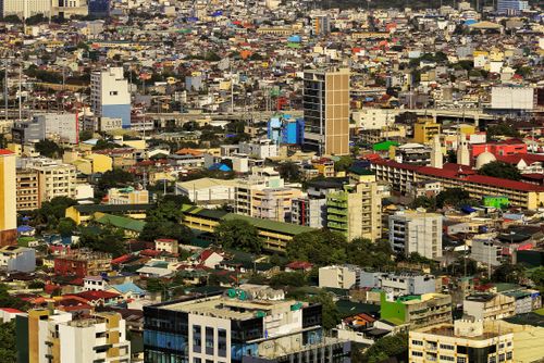 Free A bustling cityscape with diverse architecture and high-rise buildings under a clear blue sky. Stock Photo