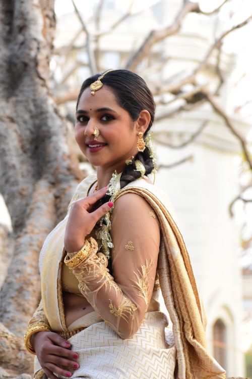 Free A smiling Indian woman poses in a traditional saree against an outdoor backdrop. Stock Photo