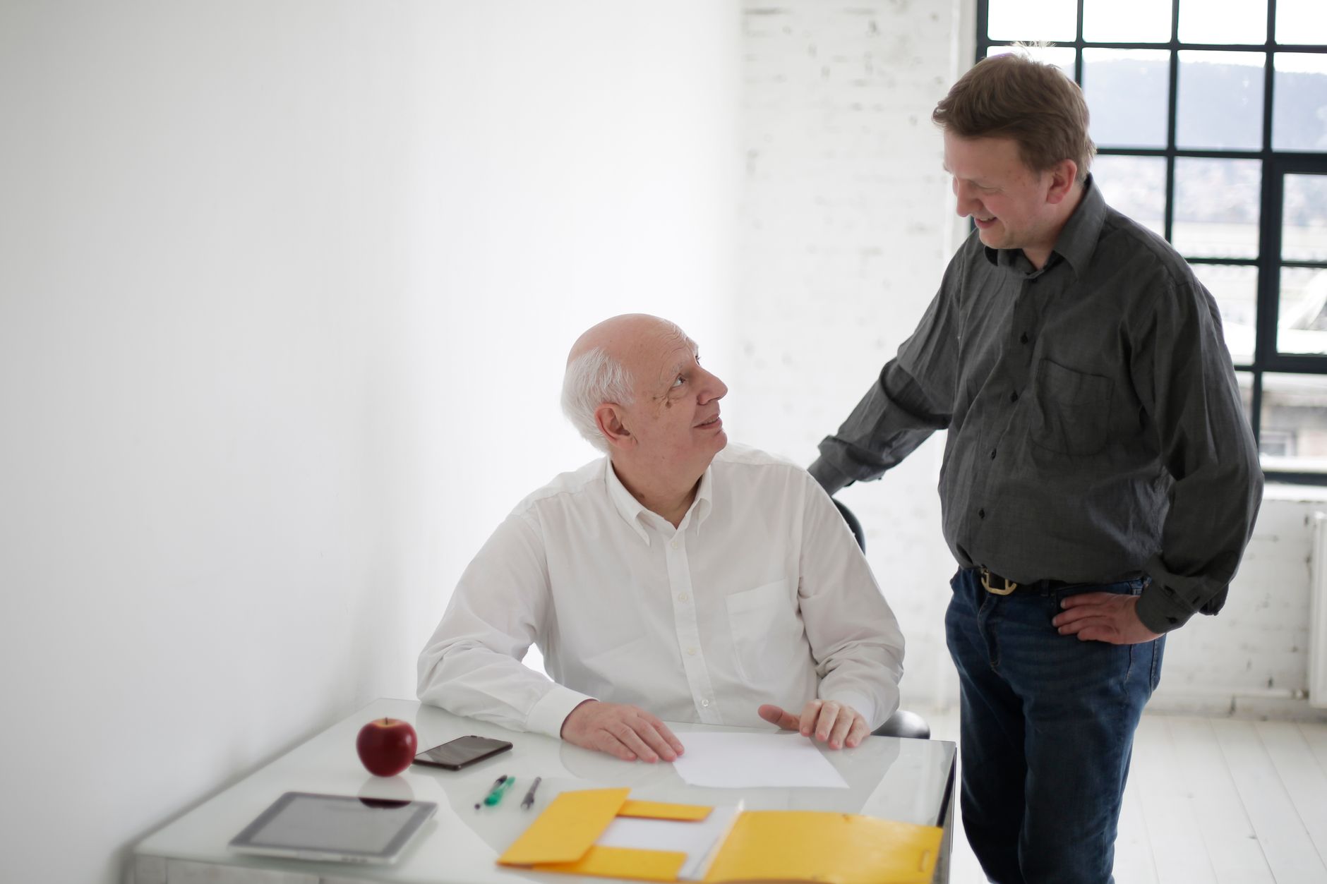 Two colleagues discussing a project at a shared workspace