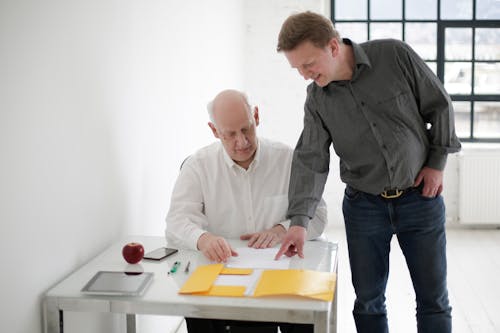 Young man explaining project to old boss