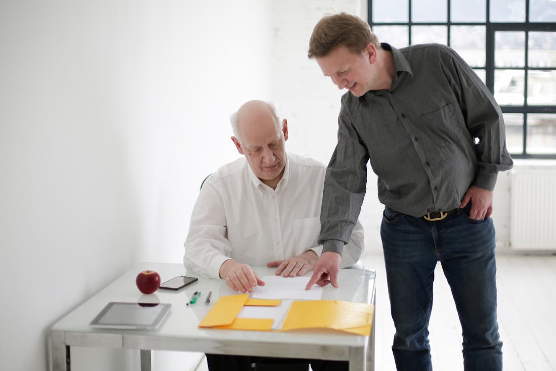 Young man explaining project to old boss