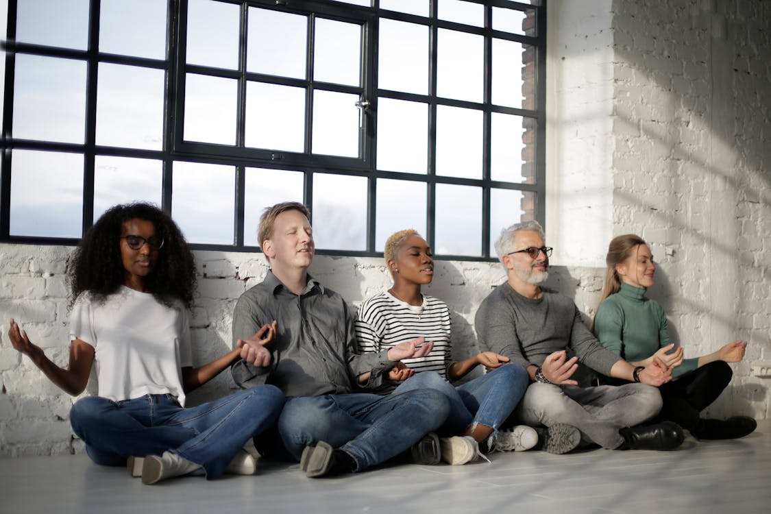 Free Cheerful calm diverse team relaxing in lotus pose Stock Photo