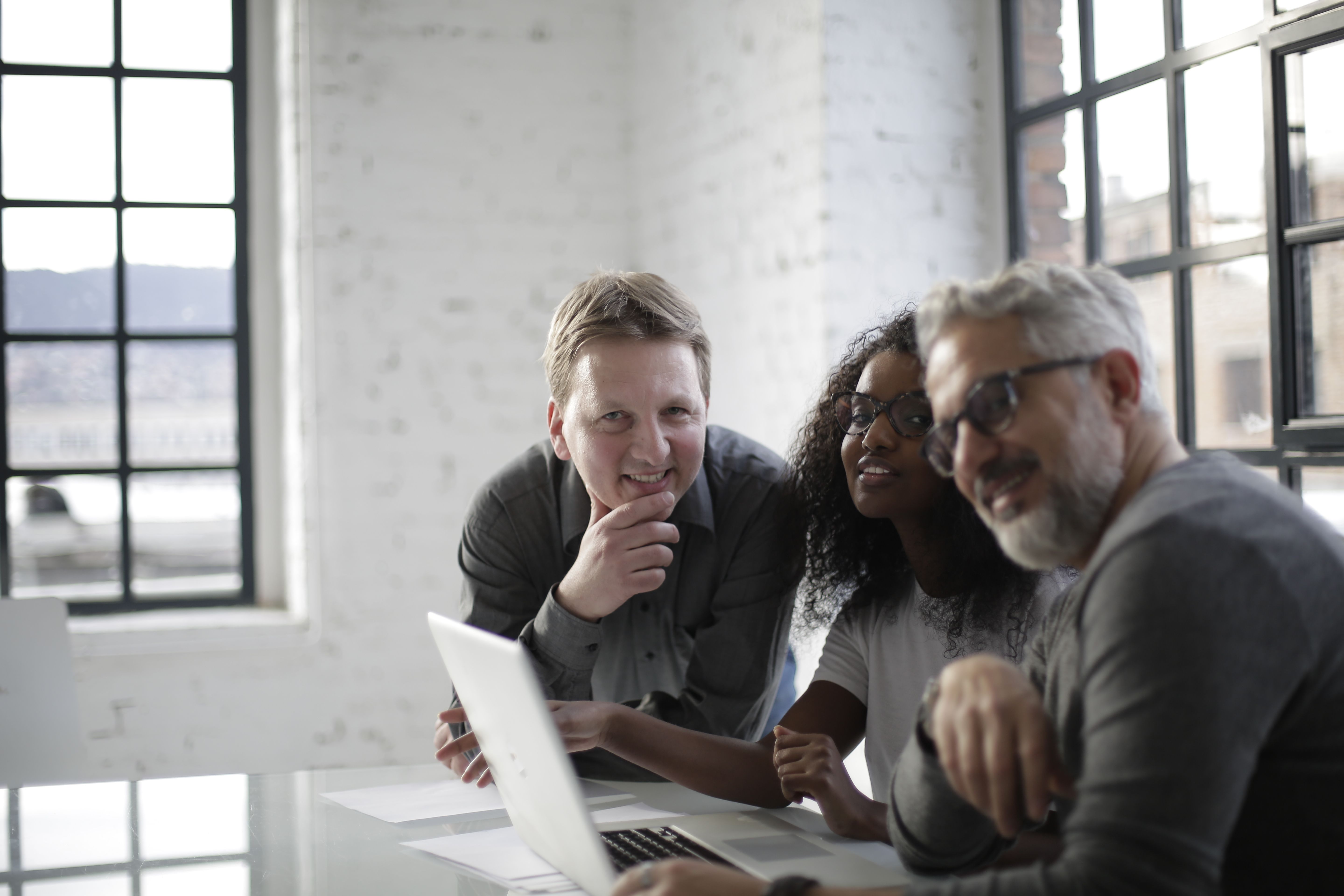 Working Together Background Computer Cheerful team with laptop working together · Free Stock Photo