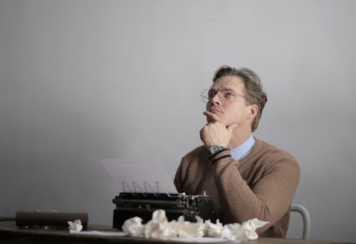 Free Adult thoughtful writer creating new article Stock Photo