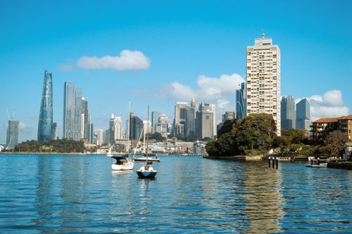 Free Boats on the tranquil Sydney Harbour with a stunning view of Sydney's iconic skyline under a clear blue sky. Stock Photo