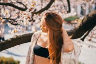 一位年轻女子在户外欣赏着充满活力的春花，营造出宁静无忧的氛围