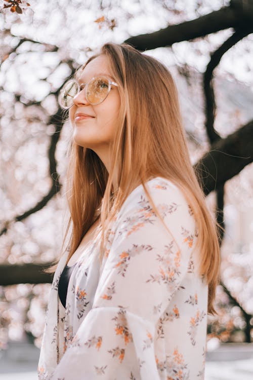 Dreamy young lady in trendy eyewear in summer day