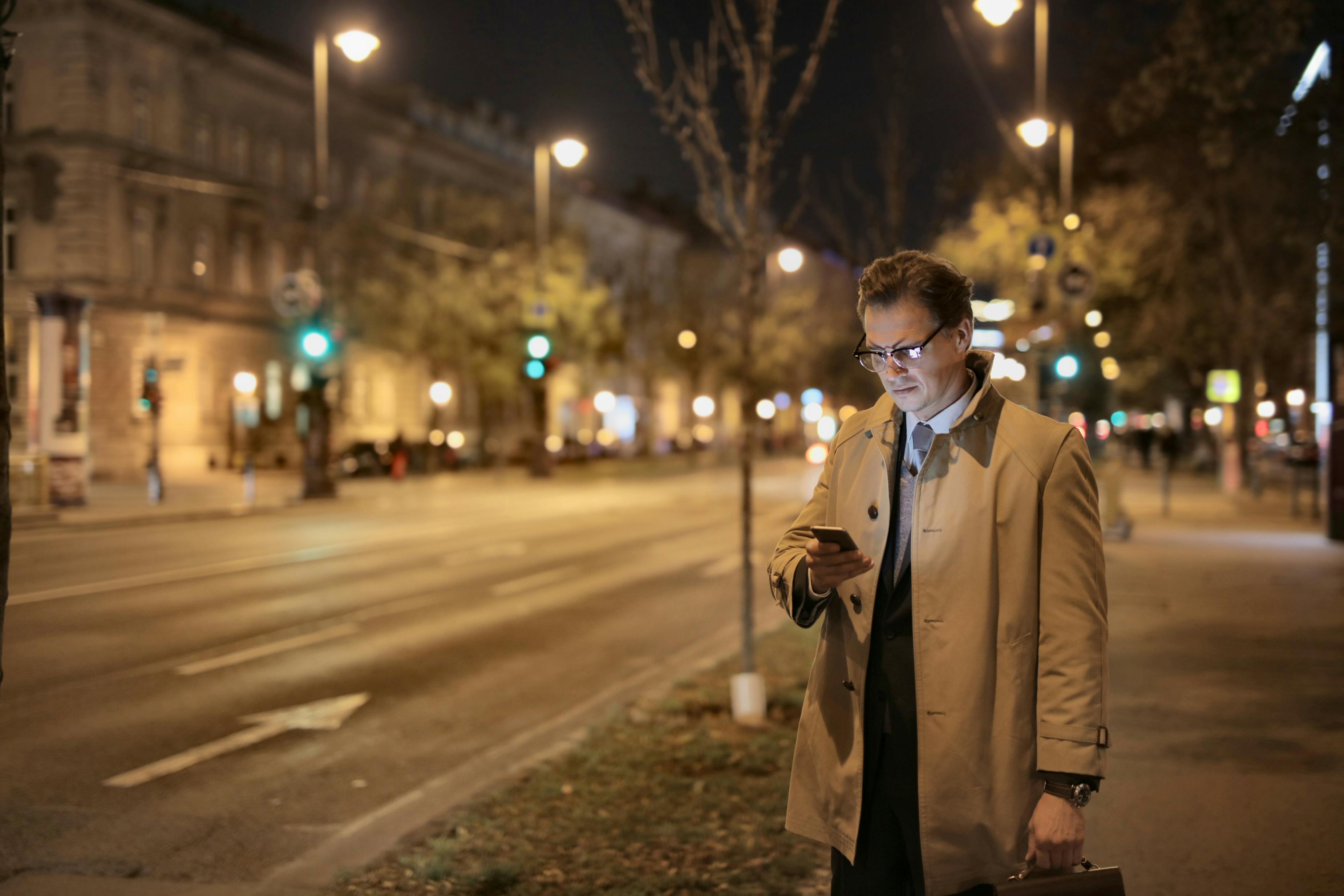 serious male with bag messaging on cellphone